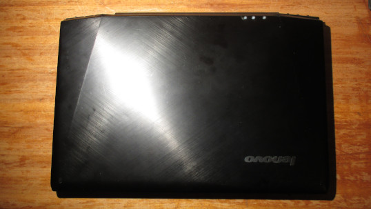 Lenovo Y50 with screen lid closed and with three holes drilled in the cover for fastening the right hinge